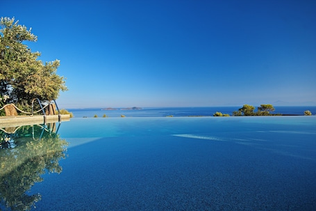 Piscina externa, guarda-sóis, espreguiçadeiras. The Infinity 180 Luxury Suites - Adults Only