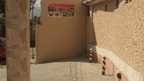A hotel entrance with a sign for Villa Rosa Hotel & Restaurant. - Villa Rosa Hotel & Restaurant (Port-au-Prince)