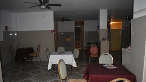 A dining area with tables and chairs, a ceiling fan, and a tiled floor. - Villa Rosa Hotel & Restaurant (Port-au-Prince)
