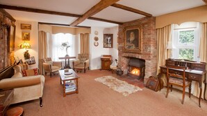 A traditional room with exposed wooden beams, a fireplace, and classic furniture. - The Old House Guesthouse (Salisbury)