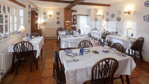 A dining area with multiple tables set for meals, surrounded by chairs. - The Old House Guesthouse (Salisbury)