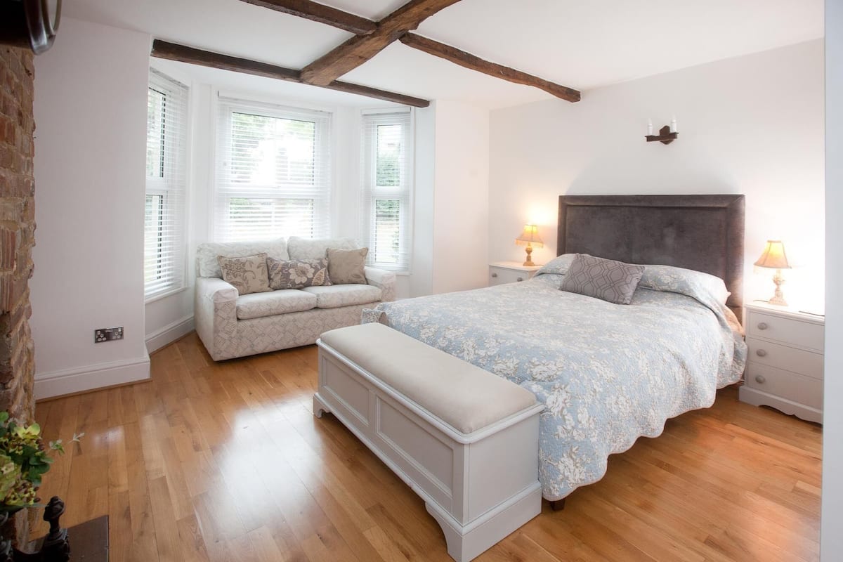 A bedroom with a bed, a bench, and a window seat.