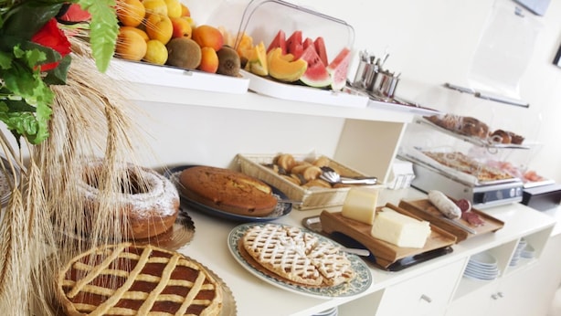 A buffet with various food items including pies, pastries, and fruits. - Hotel Corallo (Orbetello)
