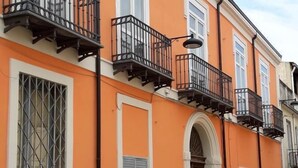 A building with orange walls, white window frames, and black balconies. - Bed and Breakfast La Mamma (Cittanova)