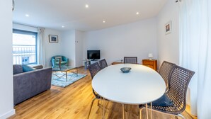 A modern living room with a round table, two sofas, and a TV. - 1Bed & 2Beds Apartment in Liverpool St by City Stay Aparts London (London)