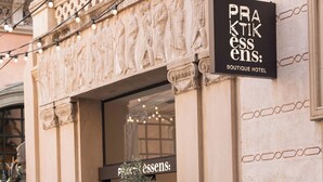 L'ingresso di un hotel boutique con un cartello che riporta la scritta "PRAKTIK ESSENS: BOUTIQUE HOTEL".