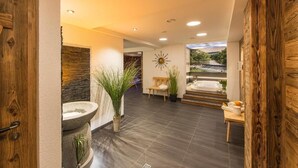 Un intérieur moderne avec un lavabo en pierre, des éléments décoratifs en bois et une vue sur l’extérieur.