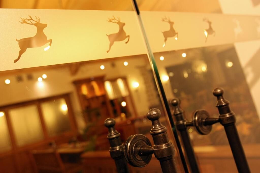 Un espejo refleja una habitación con un armario de madera y un grifo de latón.