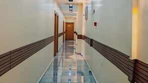 A hotel hallway with a wooden floor, a ceiling light, and a door at the end. - Rabis Otel (Sanliurfa)