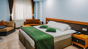 A hotel room with a bed, two chairs, a bedside table, a nightstand, and a window with curtains. - Rabis Otel (Sanliurfa)