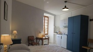 A bedroom with a bed, bedside tables, a desk, a chair, a wardrobe, and a window. - Cafe Restaurant Meuble de Tourisme (Saint-Germain-de-Calberte)