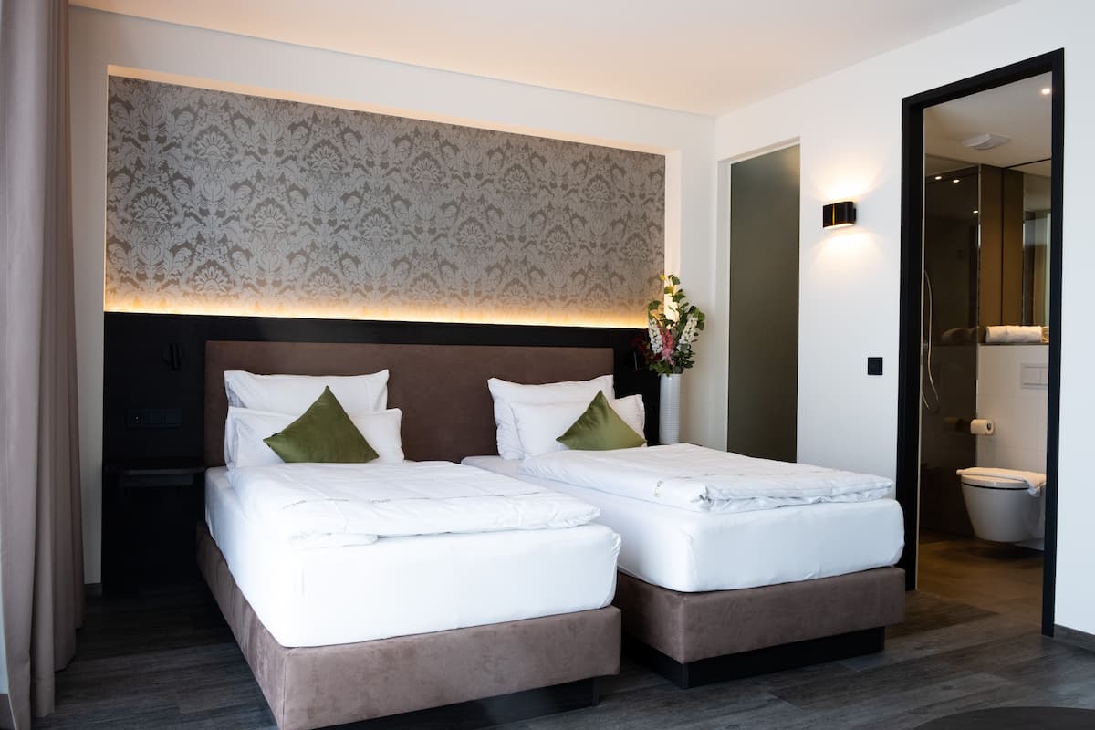 A double bed with a headboard, a bedside table, and a mirror.