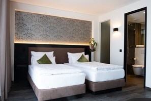 A double bed with a headboard, a bedside table, and a mirror. - in2 The Boardinghouse (Uebach-Palenberg)