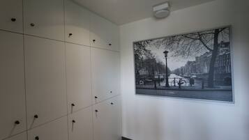 A hallway with lockers and a framed cityscape photograph on the wall.