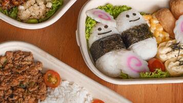 Tres recipientes tipo bento con diferentes alimentos.