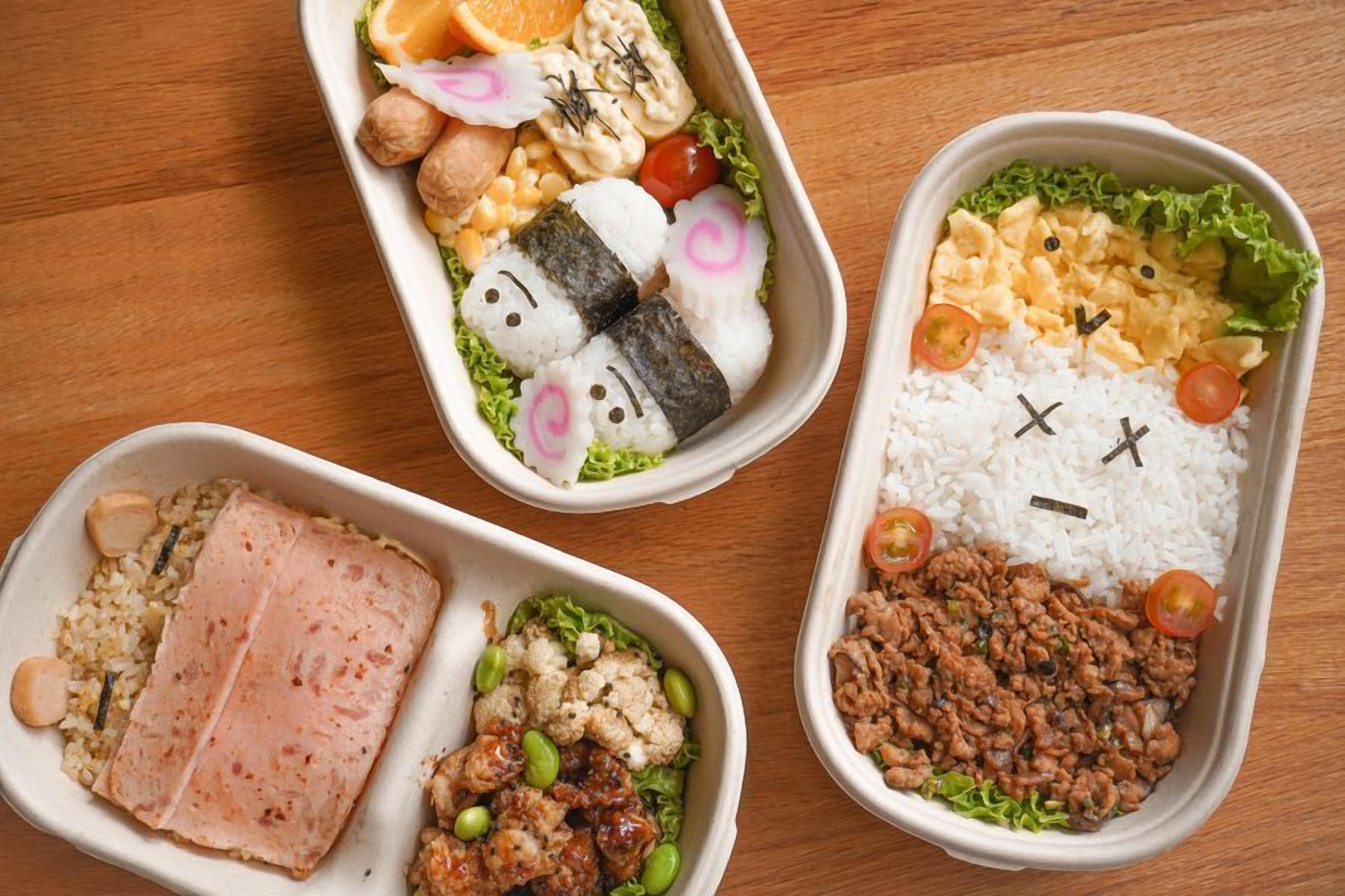 Three bento boxes with various food items.