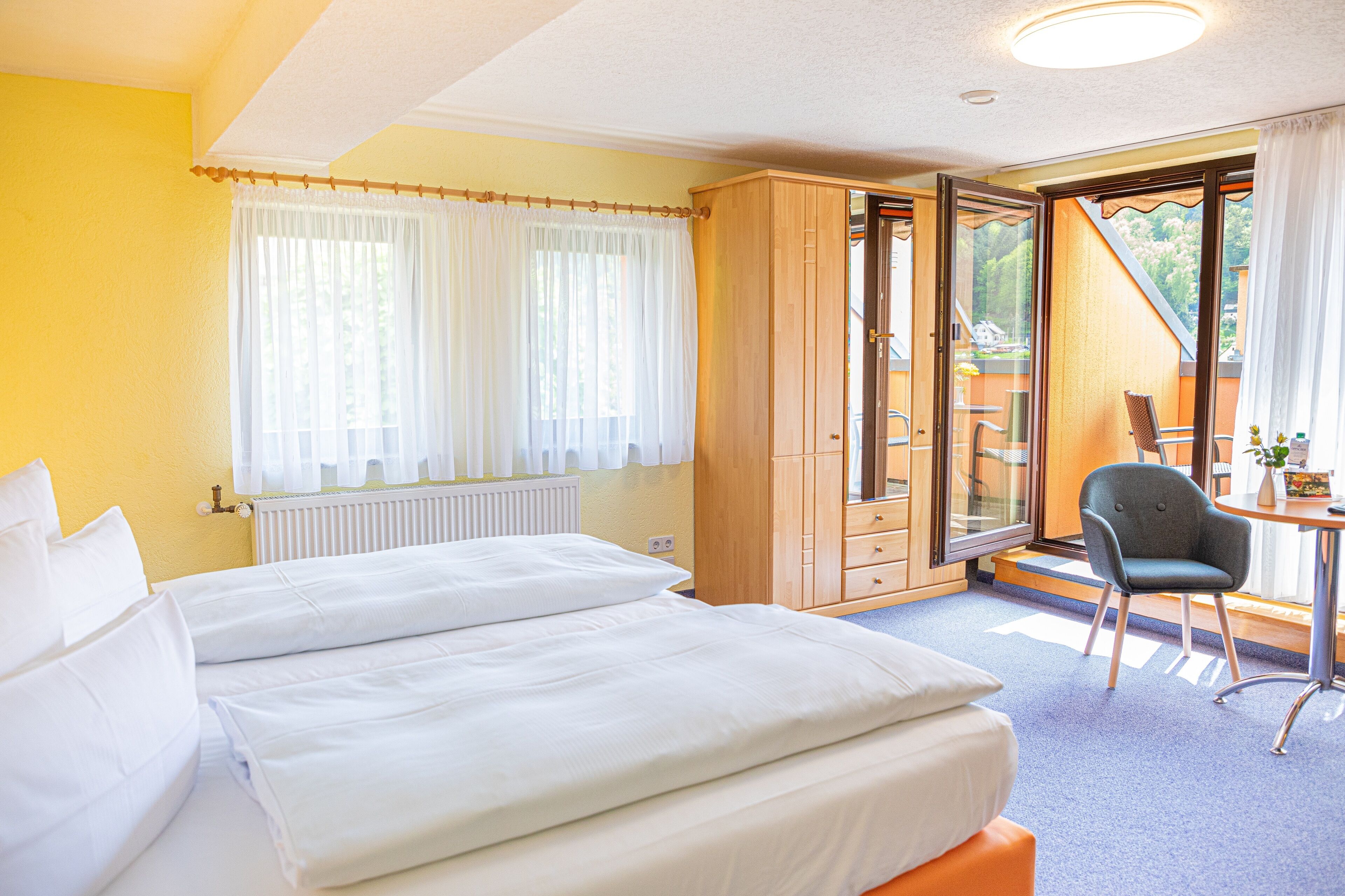 A hotel room with a bed, a desk, and a chair.