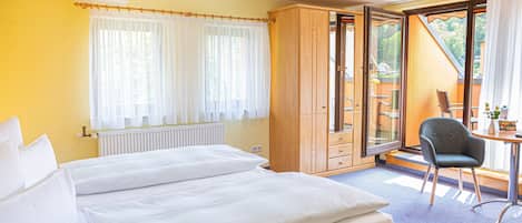 A hotel room with a bed, a desk, and a chair.