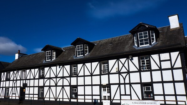 Un edificio tradicional de entramado de madera con múltiples ventanas y un cartel que anuncia Bridgford Cafe.