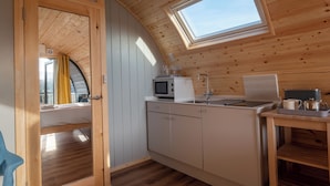 A compact kitchen with a microwave, sink, and a small table with a tray. - Callander Hostel (Callander)
