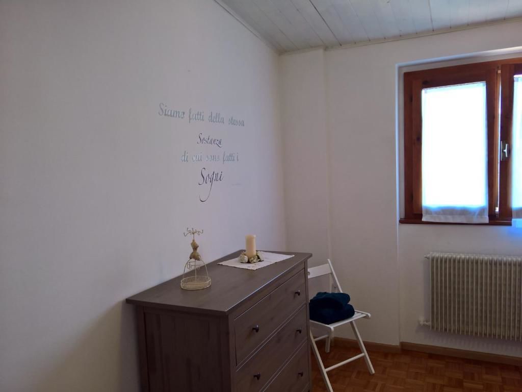 Ein Zimmer mit einem Schminktisch, einem Sessel und einem Fenster mit Blick.