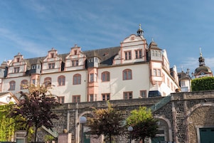 Um edifício histórico com várias janelas e uma torre imponente.