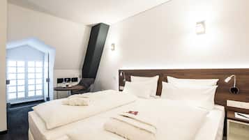 Una habitación de hotel con una cama grande, una mesita de noche, un escritorio y una silla.