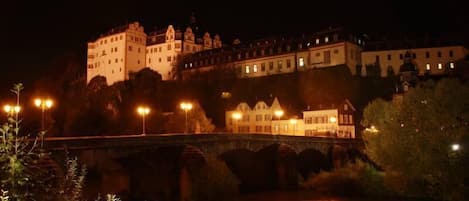 Ein historisches Gebäude mit mehreren Ebenen und einer Brücke im Vordergrund.