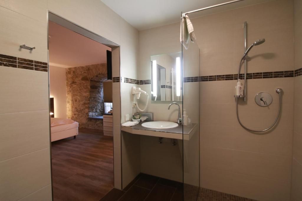 Ein Badezimmer mit Dusche, Waschbecken und Spiegel.