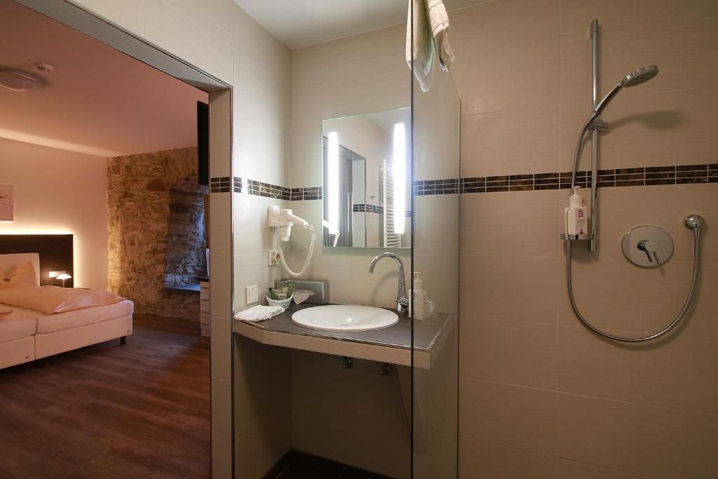 Un baño con lavabo, espejo y ducha.