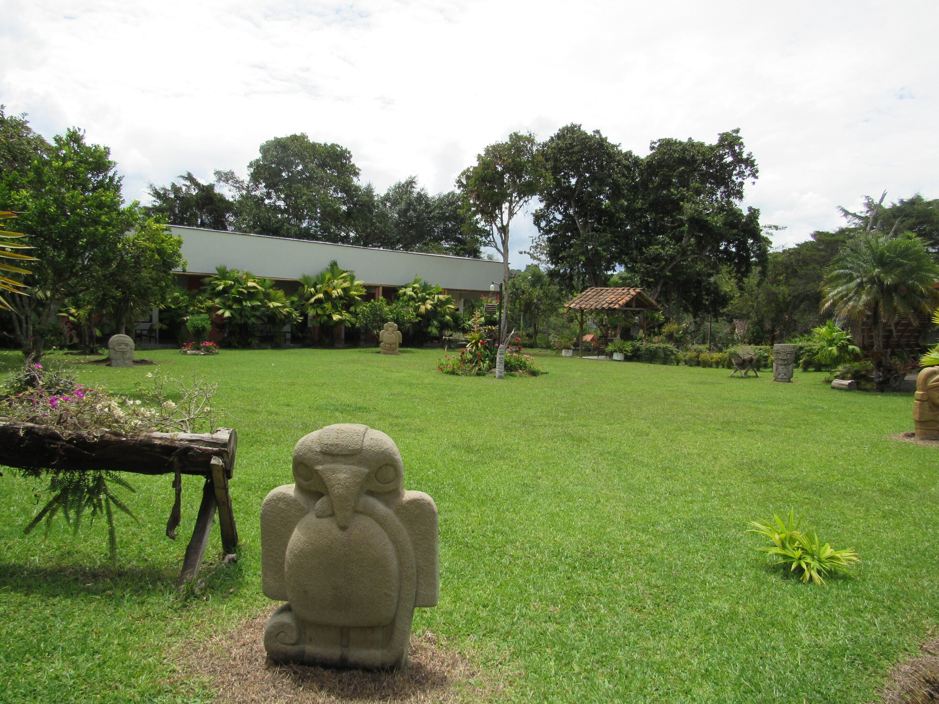 A statue in a grassy area with a building in the background.