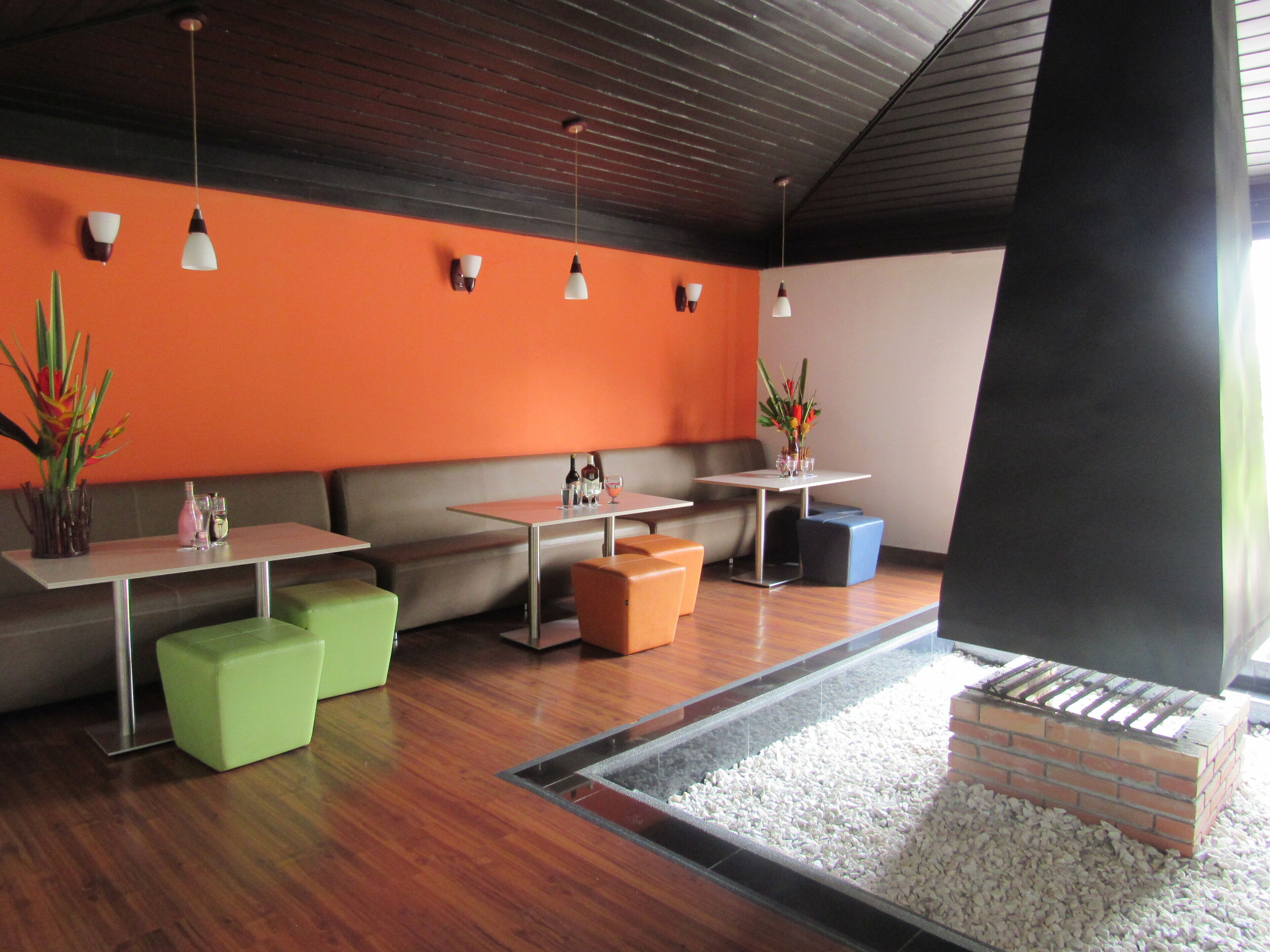 A modern interior with seating areas, tables, and a small water feature.