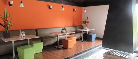 A modern interior with seating areas, tables, and a small water feature.