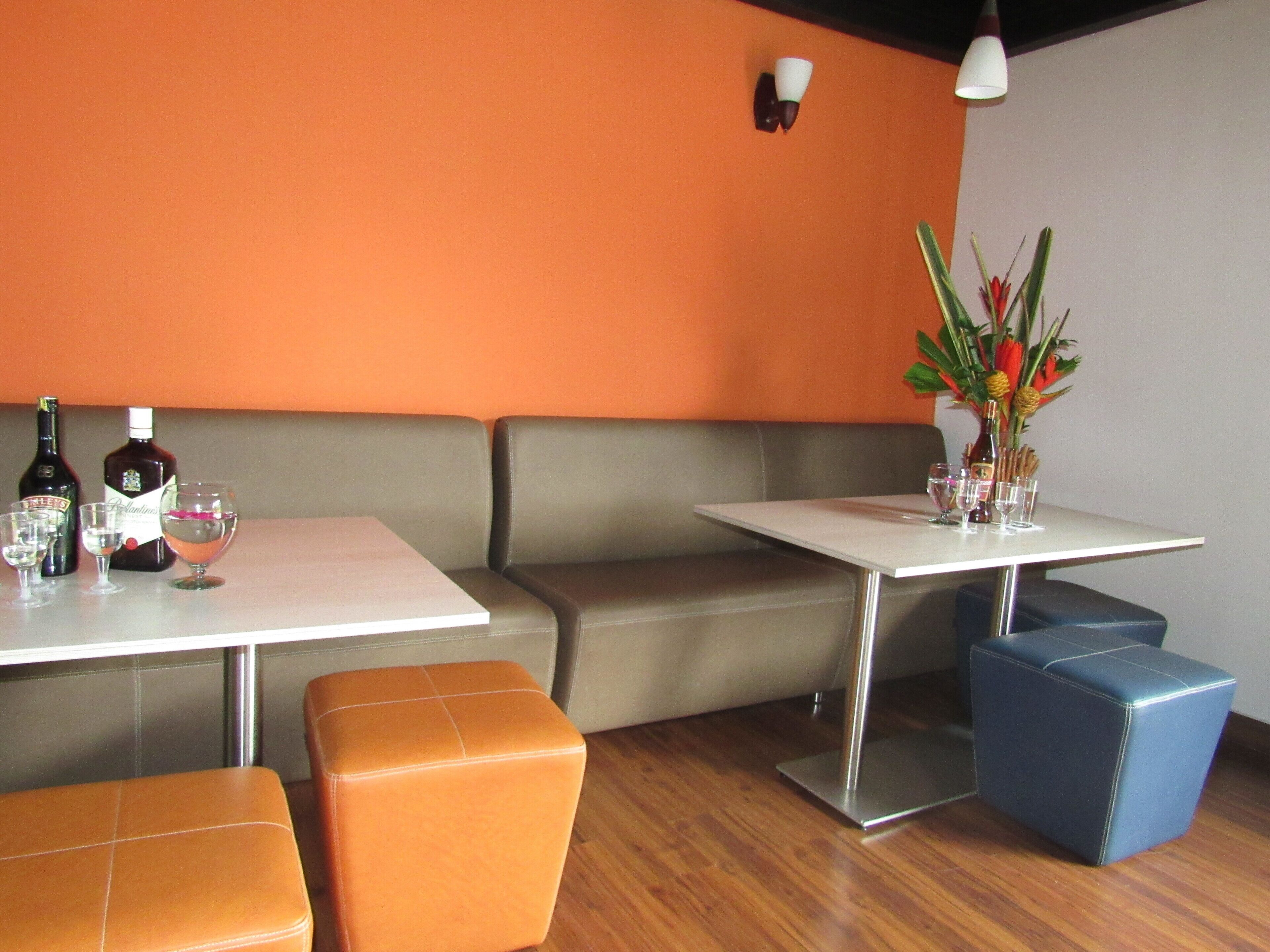 Ein Restaurantinnenraum mit einer Sitzecke und einem Tisch mit Blumen und Weinflaschen.