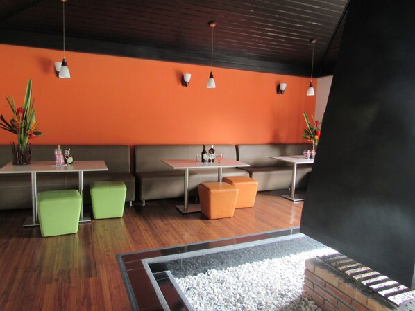 A modern interior with seating areas, tables, and hanging lights.