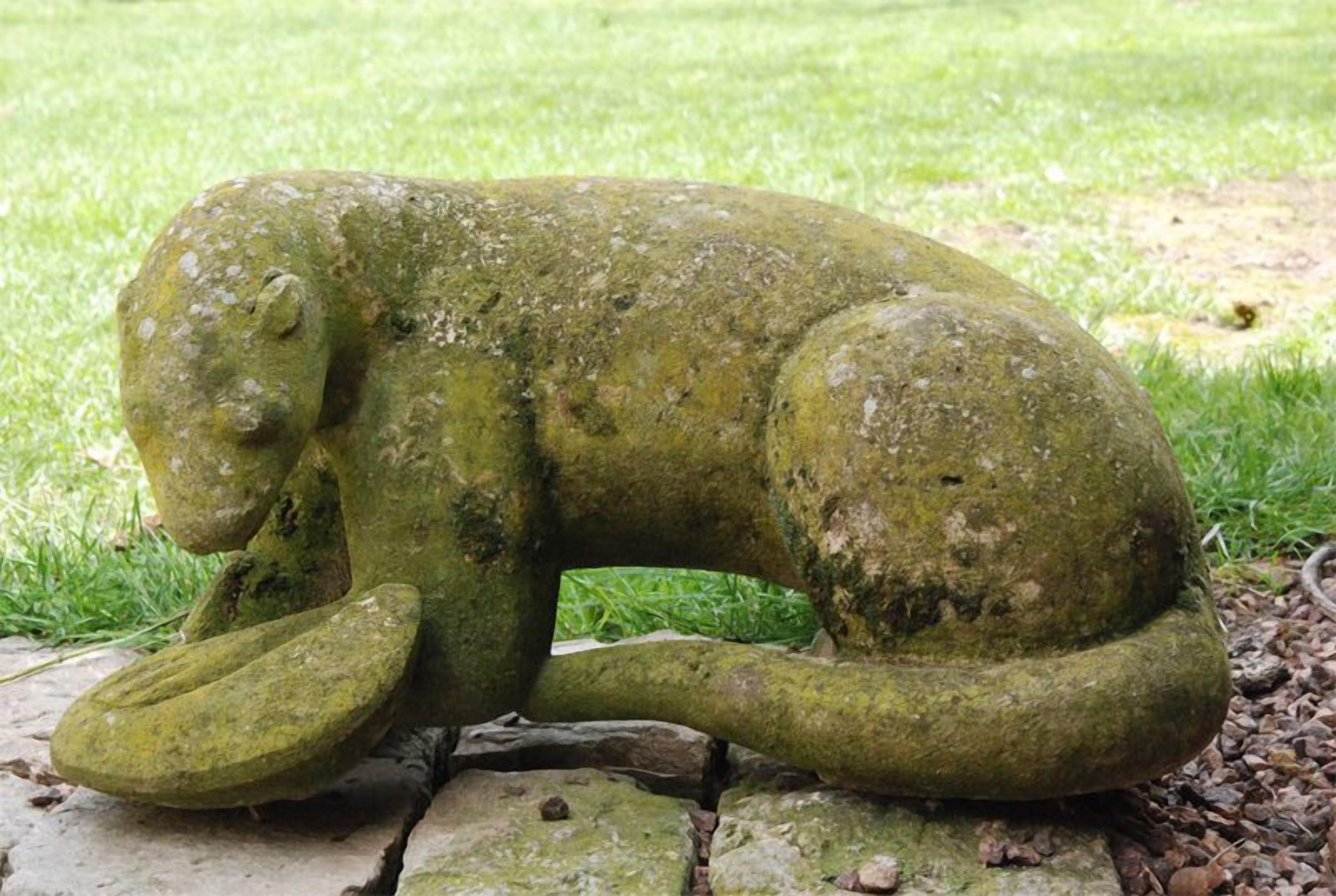 Une sculpture en pierre représentant un éléphant, placée dans un jardin.
