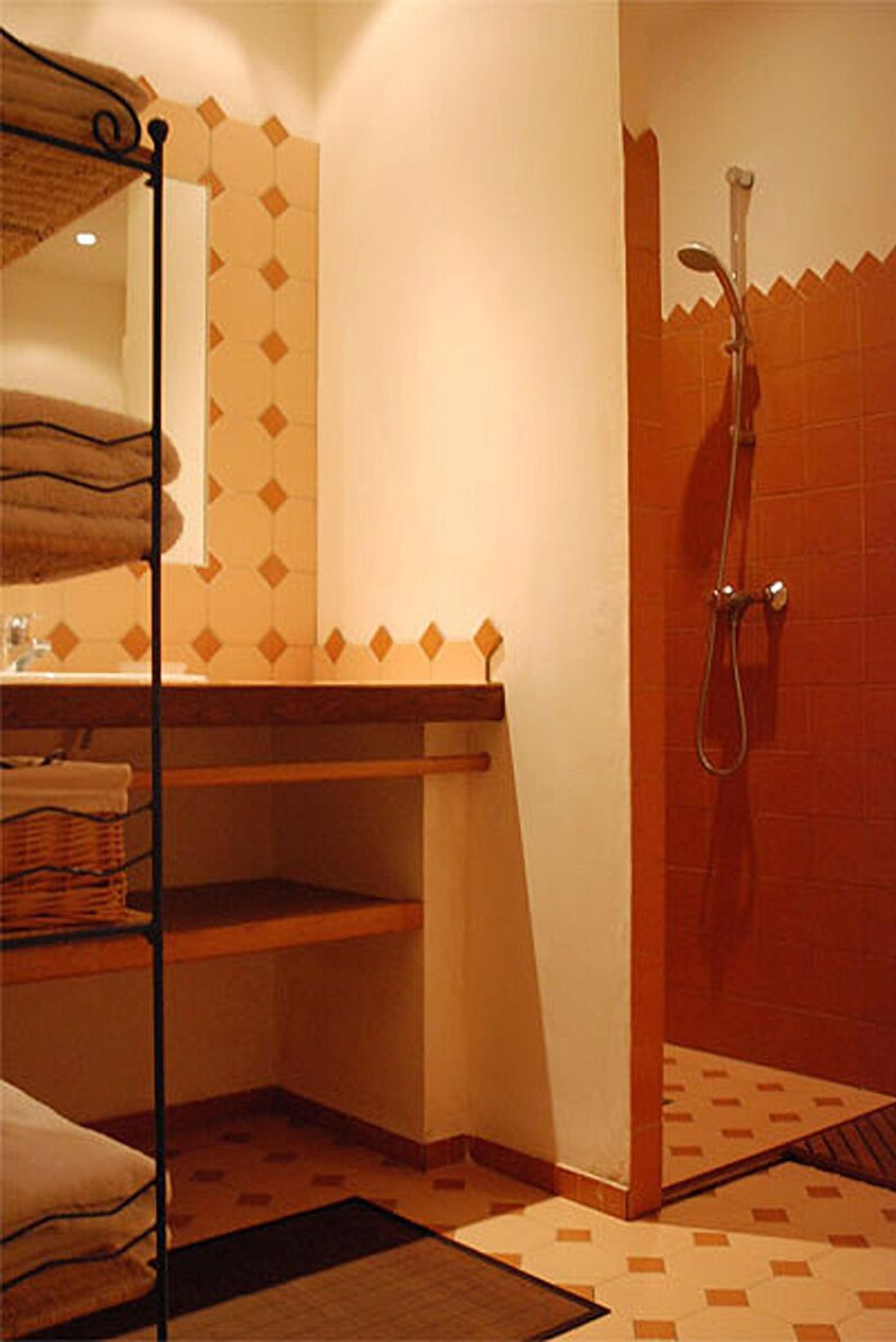 Un baño con ducha, toallero y lavamanos.
