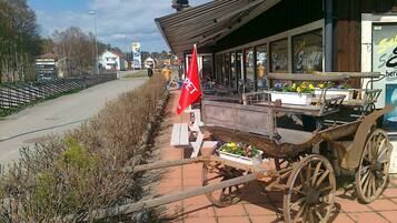 A rustic outdoor seating area with a wooden cart and a red flag, likely indicating a pet-friendly establishment.