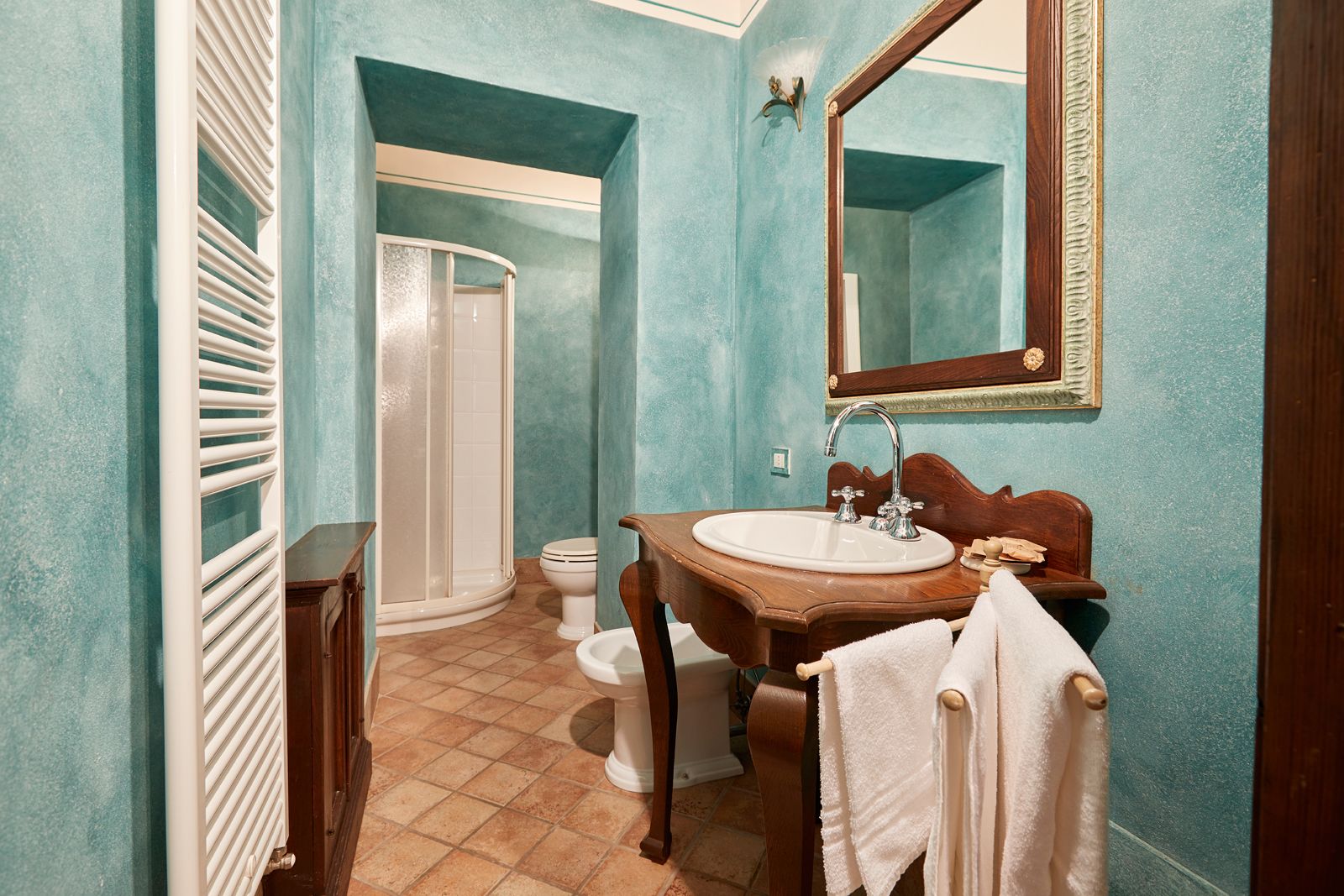 Ein Badezimmer mit Dusche, Toilette, Waschbecken und Spiegel.