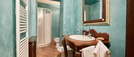Ein Badezimmer mit Dusche, Toilette, Waschbecken und Spiegel.