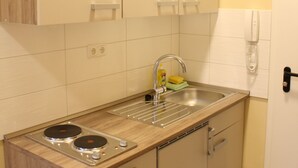 Ett kompakt kök med träskåp, en diskho och en inbyggd spis.