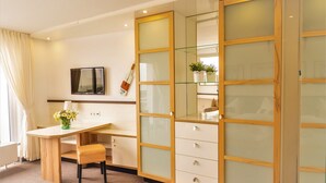 Un dormitorio con cama, escritorio, silla y armario.