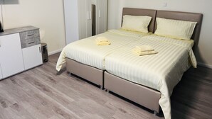 A bedroom with a bed, a wardrobe, a small table, and a television. - M&M Hotel - Neu Wulmstorf (Neu Wulmstorf)