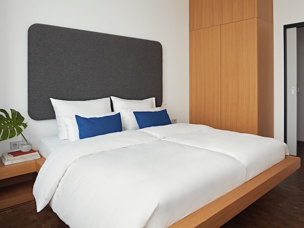 Un dormitorio moderno con cama, mesita de noche y armario.