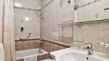 A modern bathroom with a bathtub, toilet, and sink.
