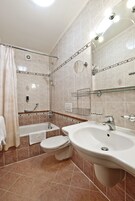 A modern bathroom with a bathtub, toilet, and sink.