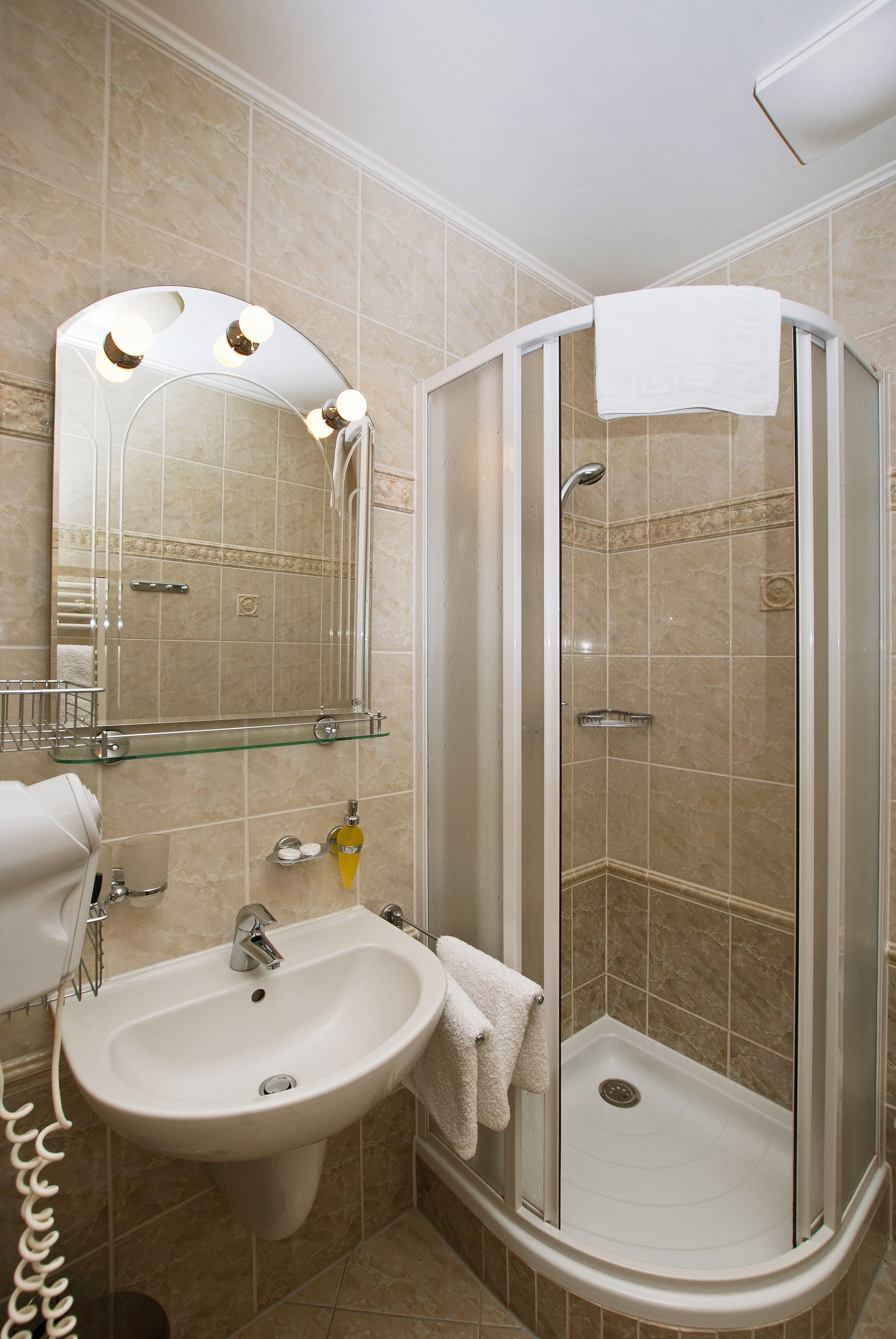 Ein Badezimmer mit Waschbecken, Spiegel und Dusche.