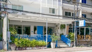A hotel with a blue facade, a covered entrance, and a staircase leading to the entrance. - Me U Hostel Pattaya (Pattaya)