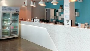 A modern bar area with a self-service counter, a refrigerated display, and pendant lighting. - Me U Hostel Pattaya (Pattaya)