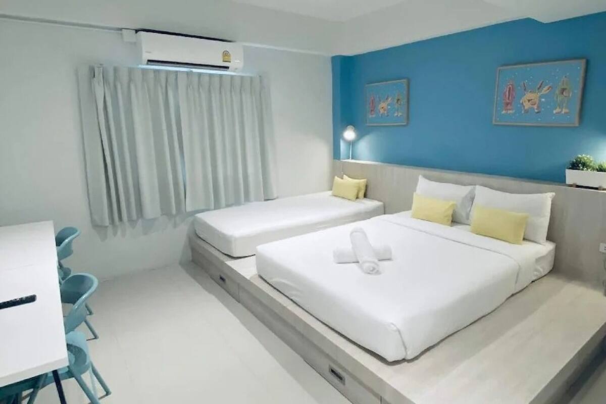Ein modernes Hotelzimmer mit zwei Betten, einem Schreibtisch und einem Stuhl.